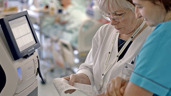 Hospital situation - two people investigating the paper result from a Radiometer blood gas anlyzer